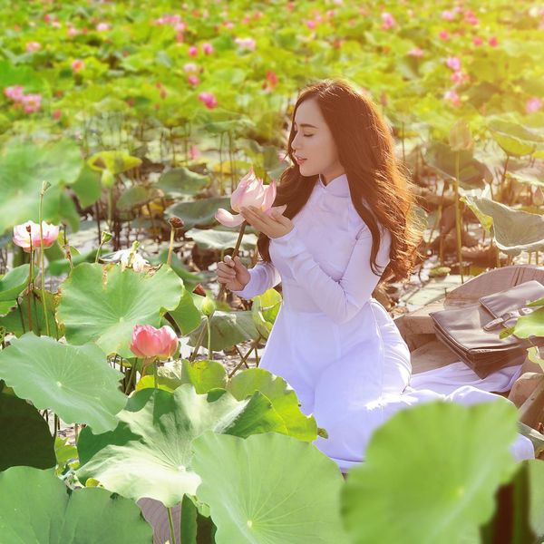 Person sitting in a lotus meditation pose with a serene natural landscape behind.